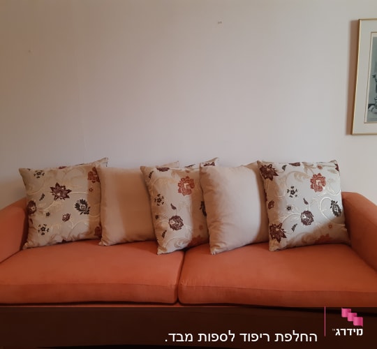 כריות דקורטיביות על ספה כתומה